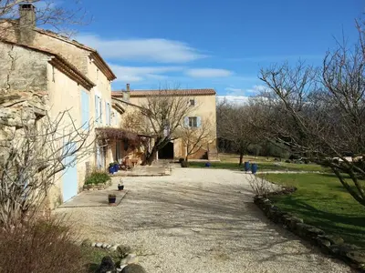 a stone driveway leading to a large building at Le Mas Saint Jacques in Crillon-le-Brave
