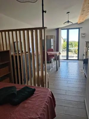 a bedroom with a bed and a dining room with a table at Gite l'épinette in Saint-Saturnin-les-Apt