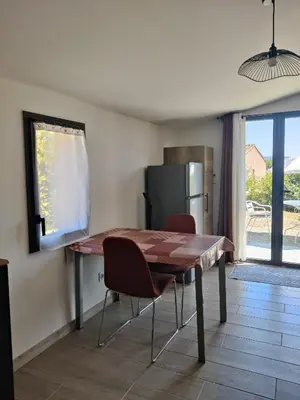 a kitchen with a table and chairs and a refrigerator at Gite l'épinette in Saint-Saturnin-les-Apt