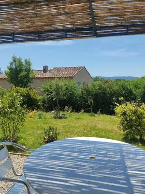 a table and chairs in a yard with a house at Gite l'épinette in Saint-Saturnin-les-Apt
