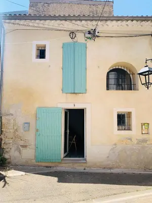 a building with green shutters and a door at Le Nid Provençal in Lambesc
