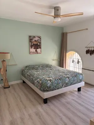 a bedroom with a bed and a ceiling fan at Le Nid Provençal in Lambesc