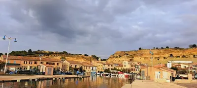 a town with a river and buildings and a hill at Appartement dans mas avec piscine privée sans vis a vis in Miramas
