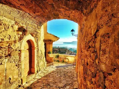 an alley in a stone wall with an archway at Appartement dans mas avec piscine privée sans vis a vis in Miramas