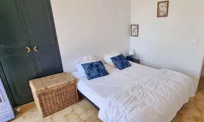 a bedroom with a bed with two blue pillows on it at Appartement dans mas avec piscine privée sans vis a vis in Miramas