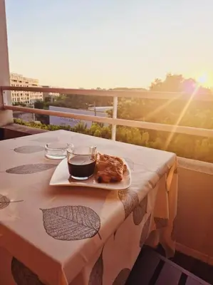 a table with a plate of food on a balcony at T3 Panoramique Centre Aix en Provence in Aix-en-Provence