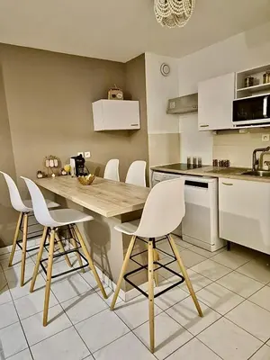 a kitchen with a wooden table and white chairs at T3 Panoramique Centre Aix en Provence in Aix-en-Provence