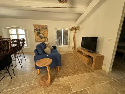 a living room with a blue couch and a tv at La bohème in Lourmarin