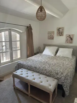 a bedroom with a bed and a large window at La bohème in Lourmarin
