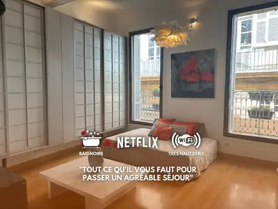 a living room with windows and a couch and a table at Le Loft du Matheron in Aix-en-Provence