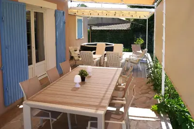 a patio with a wooden table and chairs at Anna et Jean-Paul in LʼIsle-sur-la-Sorgue