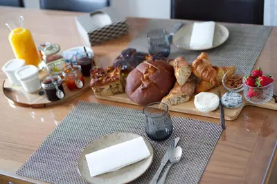a table with a tray of bread and pastries on it at Anna et Jean-Paul in LʼIsle-sur-la-Sorgue