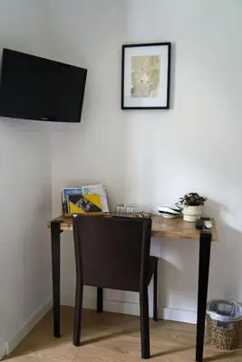 a desk with a chair and a television on a wall at Anna et Jean-Paul in LʼIsle-sur-la-Sorgue