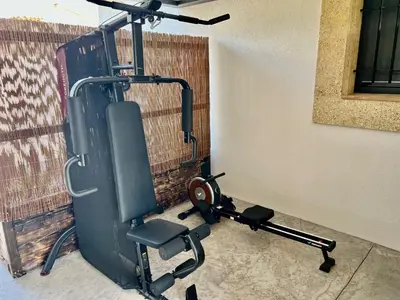 a room with a gym with a bench and a exercise bike at Une nuit en Luberon et SPA in Puyvert
