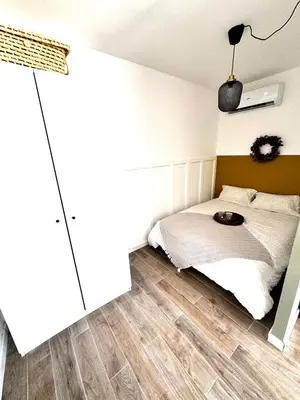 a bedroom with a bed with a white bedspread at Charmant T2 atypique proche du centre-ville in Miramas