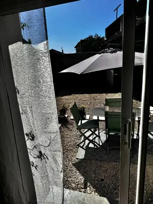 a patio with a table and a white umbrella at Charmant T2 atypique proche du centre-ville in Miramas