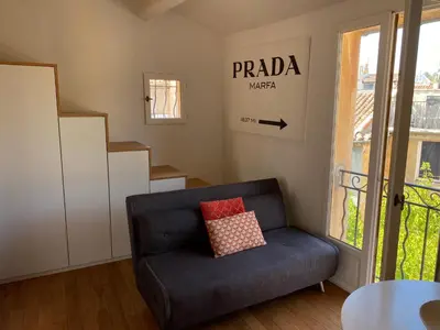 a living room with a blue couch and a staircase at Studio centre historique Aix en Provence in Aix-en-Provence