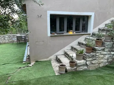 a house with some potted plants in a yard at Charmante Maison au cœur du village in Rustrel