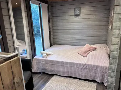 a small bedroom with a bed in a house at Éco Lodge - Nature et Spa in Aurons