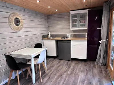 a kitchen with a table and chairs in a room at Éco Lodge - Nature et Spa in Aurons