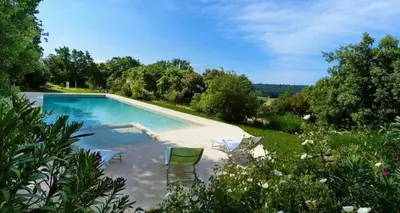 a swimming pool with chairs in a garden at Éco Lodge - Nature et Spa in Aurons