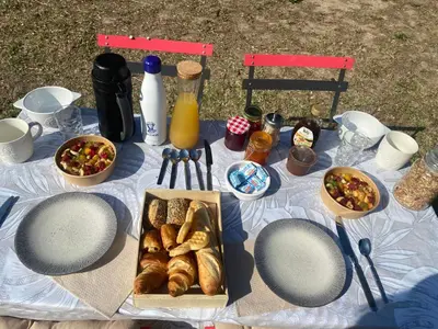 a picnic table with bread and other food and drinks at Éco Lodge - Nature et Spa in Aurons
