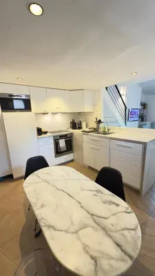 a white kitchen with a table and chairs in it at Appartement climatisé 2 chambres Centre historique in Aix-en-Provence