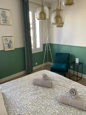 a bedroom with a bed and a blue chair at Appartement climatisé 2 chambres Centre historique in Aix-en-Provence