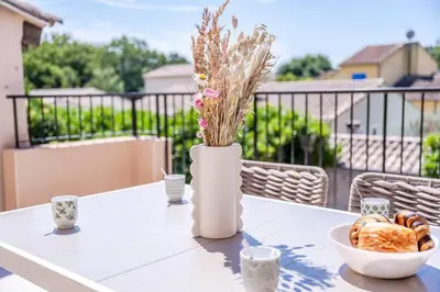 a table with a bowl of bread and a vase with flowers at Tropiques en Provence in Morières-lès-Avignon