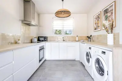 a kitchen with white cabinets and a washer and dryer at Tropiques en Provence in Morières-lès-Avignon