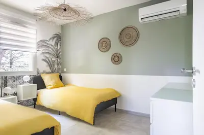a bedroom with two beds and a yellow blanket at Tropiques en Provence in Morières-lès-Avignon