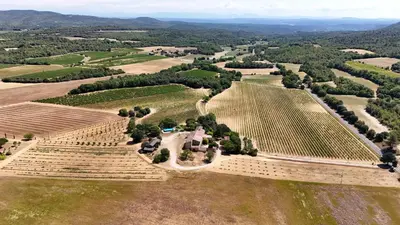 a yard with green grass and trees and a building at Domaine Camp Fourca in Mirabeau