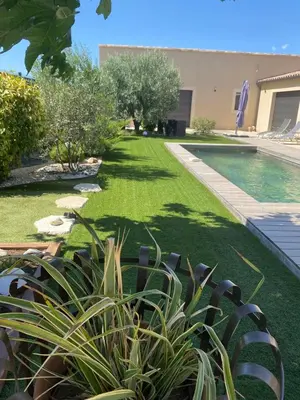 a garden with a swimming pool and a lawn at La bastide de marie in Robion en Luberon