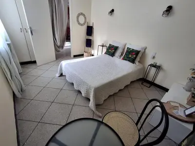 a bedroom with a bed and a table and chairs at Chambre à louer à la nuitée in Sénas