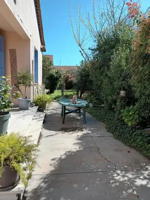 a cat sitting on a bench in a garden at Chambre à louer à la nuitée in Sénas