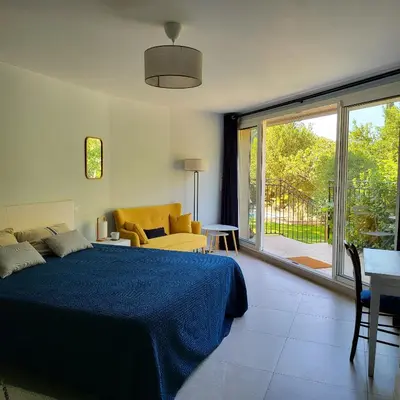 a bedroom with a bed and a couch and a window at Villa Hélène in Aix-en-Provence