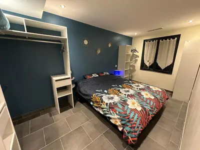 a bedroom with a bed and a blue wall at Maison Isle sur la sorgue in LʼIsle-sur-la-Sorgue