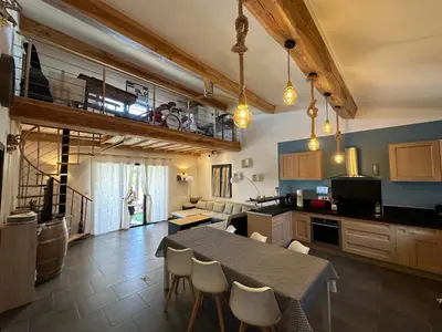a kitchen and dining room with a table and chairs at Maison Isle sur la sorgue in LʼIsle-sur-la-Sorgue