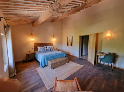 a bedroom with a bed and a table and a chair at Bastide des 7 Sœurs in Roussillon