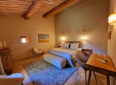 a bedroom with a bed and a table and chairs at Bastide des 7 Sœurs in Roussillon
