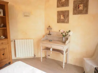 a bedroom with a table with a vase of flowers on it at La maison Danna in Lauris
