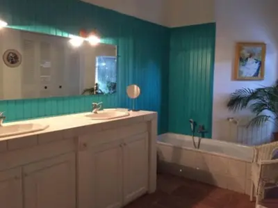 a bathroom with two sinks and a tub and a mirror at La maison Danna in Lauris