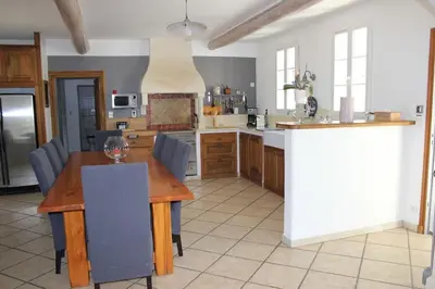 a large kitchen with a wooden table and chairs at Mas Aubert in Eyragues