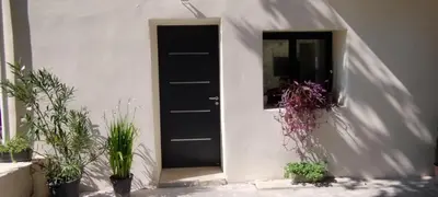 a black door with potted plants in front of it at Mas en Provence in Le Thor