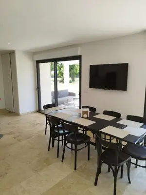 a room with a table and chairs and a flat screen tv at Mas en Provence in Le Thor