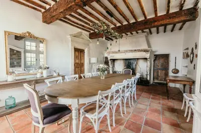 a dining room with a table and chairs and a fireplace at Le Bas Château Provence Luberon in Saint-Michel-lʼObservatoire