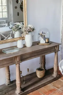 a console table with flowers and a mirror at Le Bas Château Provence Luberon in Saint-Michel-lʼObservatoire