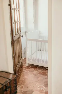 an open door with a baby crib in a room at Le Bas Château Provence Luberon in Saint-Michel-lʼObservatoire