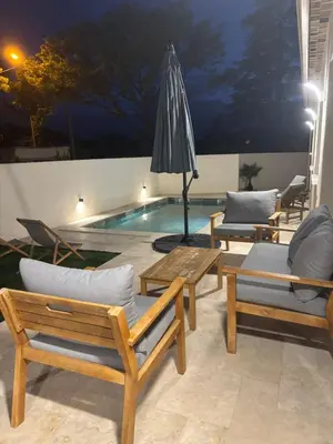 a pool with chairs and a table and an umbrella at Villa Zen in Entraigues-sur-la-Sorgue