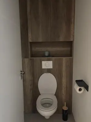 a bathroom with a toilet with a wooden wall at Villa Zen in Entraigues-sur-la-Sorgue